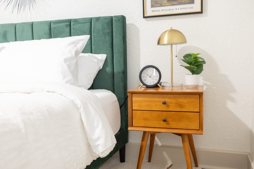 Primary bedroom with green velvet headboard